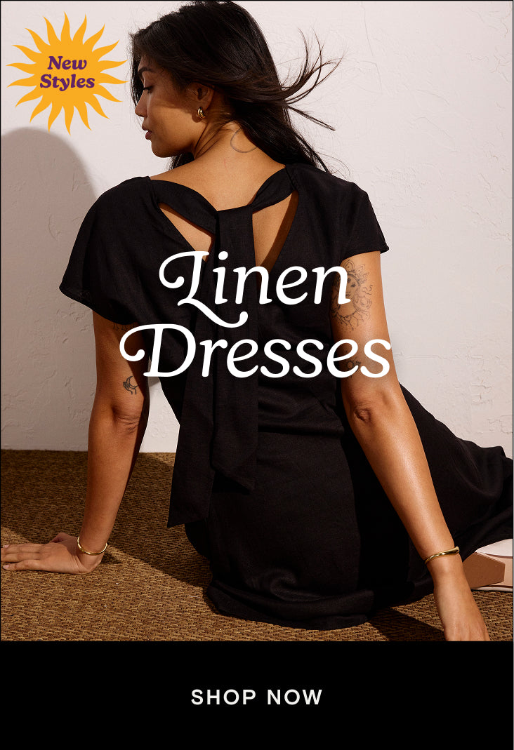 woman wearing black linen dress with tie at the back and a cta that links to the linen dresses