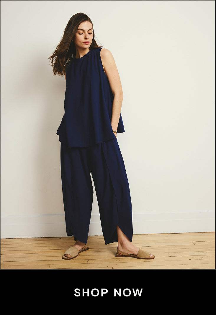 model wearing navy pants and tank with shop now button that links to jumpsuits and bottoms in the effortless summer styles collection