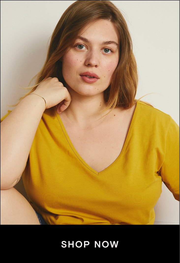 model wearing yellow vneck tee with shop now button that links to short sleeve tees in the effortless summer styles collection