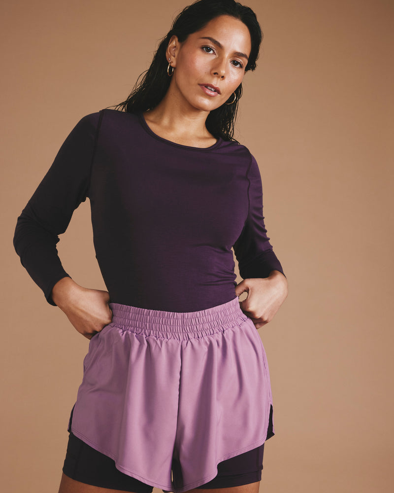 Woman wearing Rebel Active Shorts - Purple/Purple Jewel from Universal Standard