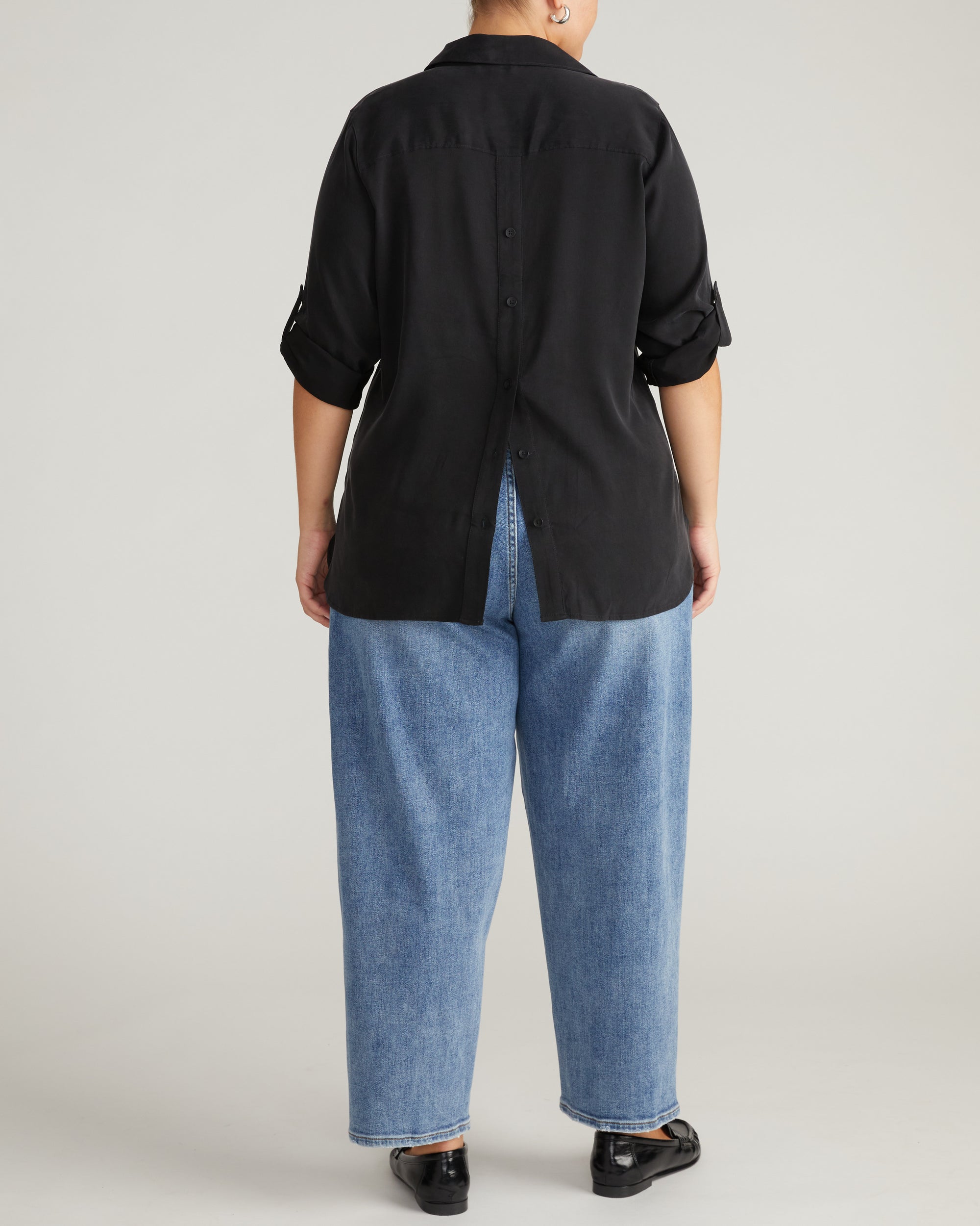 Woman wearing Button Back Stretch Cupro Polo Shirt - Black from Universal Standard